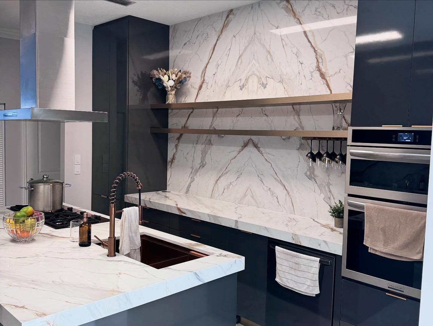 Navy kitchen with bookmatched marble wall