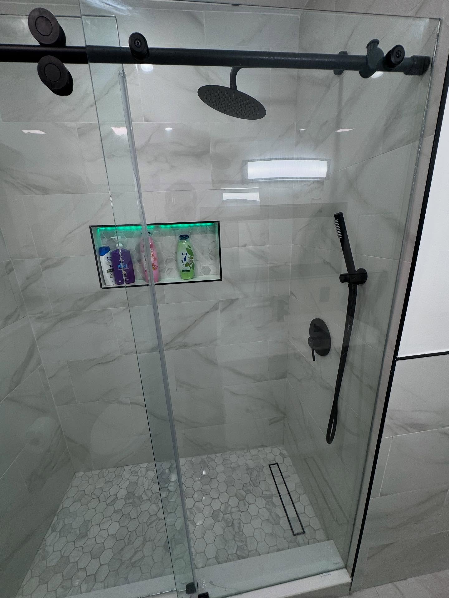 Frameless glass marble shower remodel by Star Group Construction